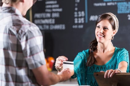 Woman working in restaurant taking payment from customer