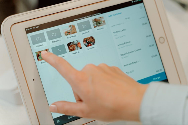 Free Finger tapping on a tablet screen to select food items in a restaurant setting. Stock Photo